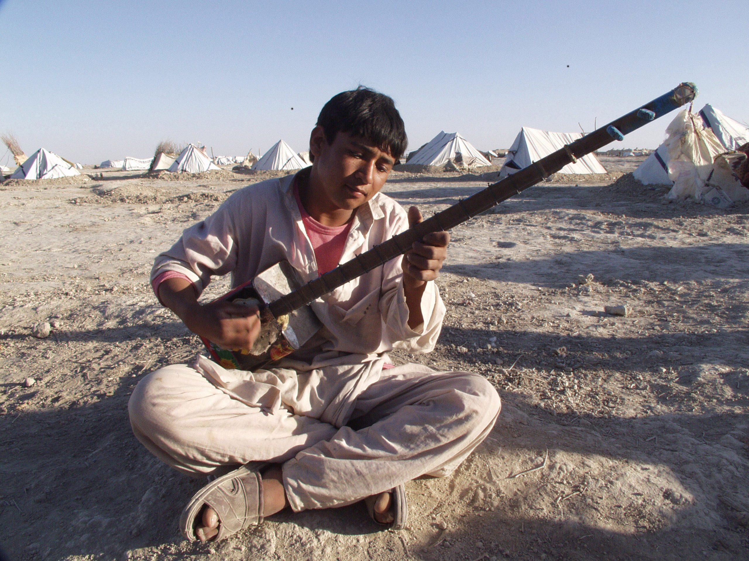 Young man playing handmade tanbur in Afghanistan